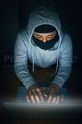 Buy stock photo High angle shot of a man in a hoodie and mask hacking a computer network