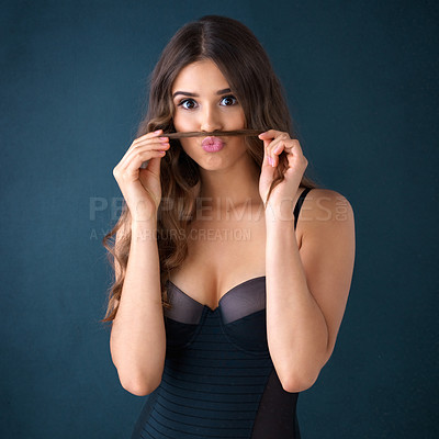 Buy stock photo Studio portrait of an attractive young woman posing in lingerie against a dark background