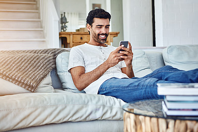 Buy stock photo Typing, smile and man with mobile on sofa for texting, communication or notification in living room. Relax, connection and person with smartphone for social media, networking or internet app in home