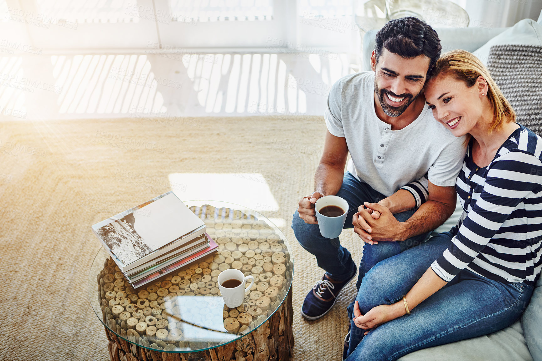 Buy stock photo High angle shot of an affectionate young couple having coffee together at home