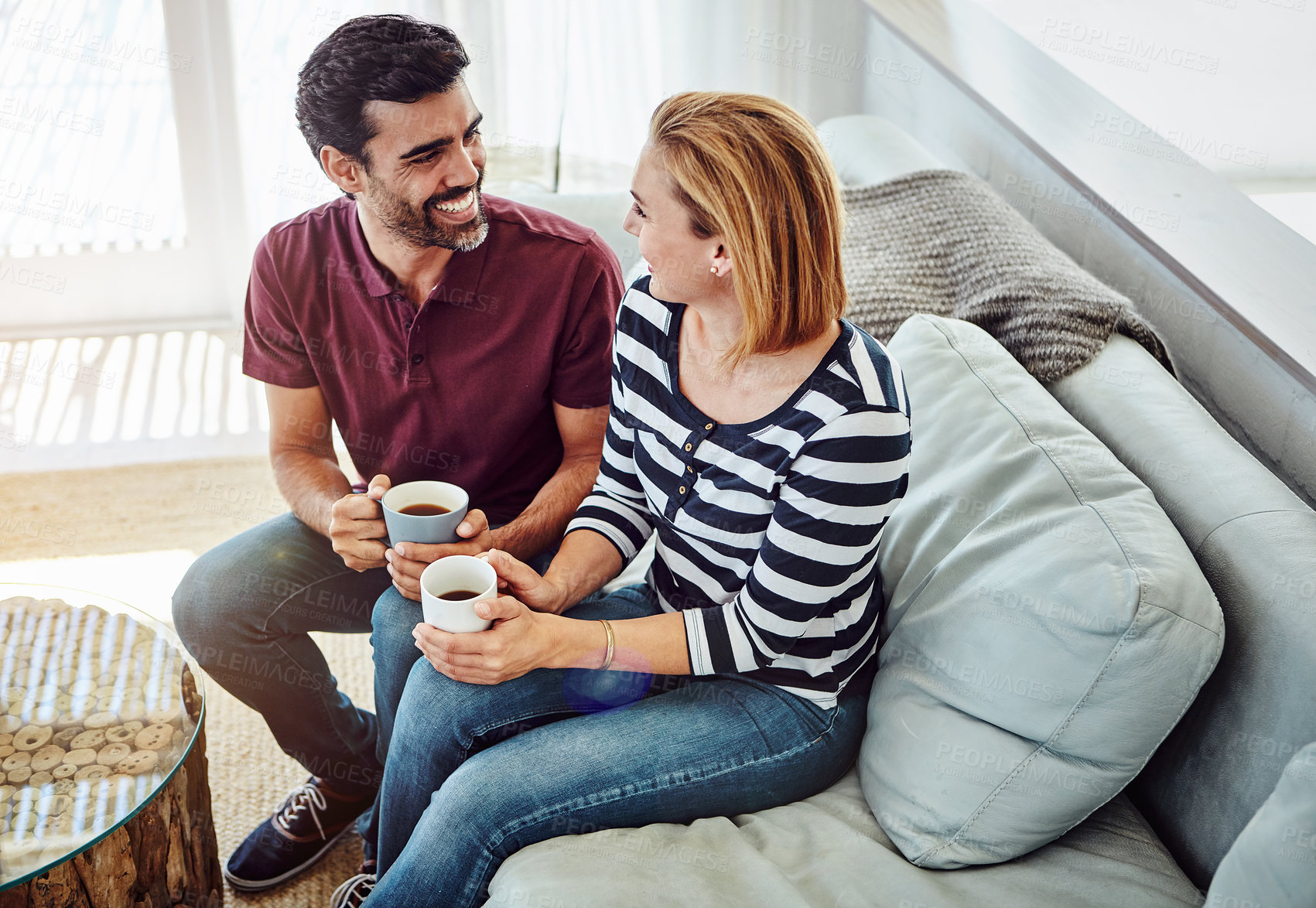 Buy stock photo High angle shot of an affectionate young couple having coffee together at home