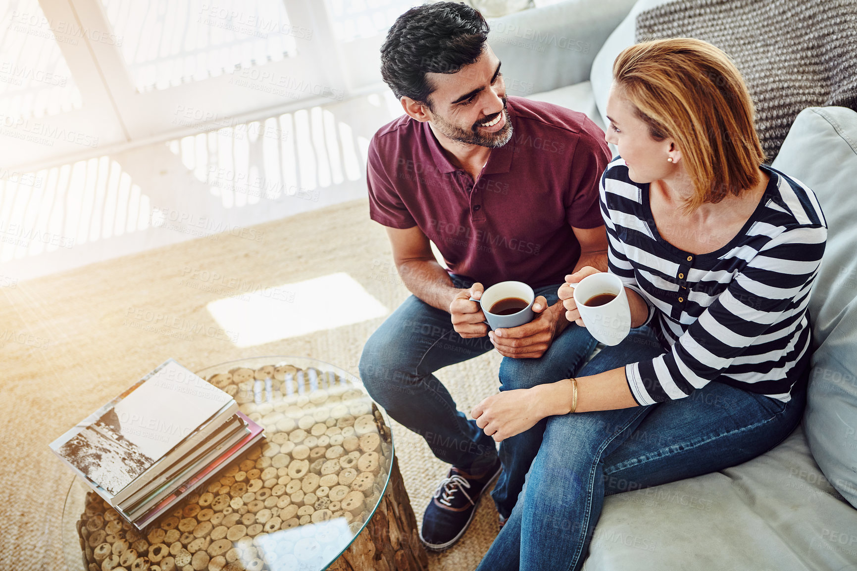 Buy stock photo High angle shot of an affectionate young couple having coffee together at home