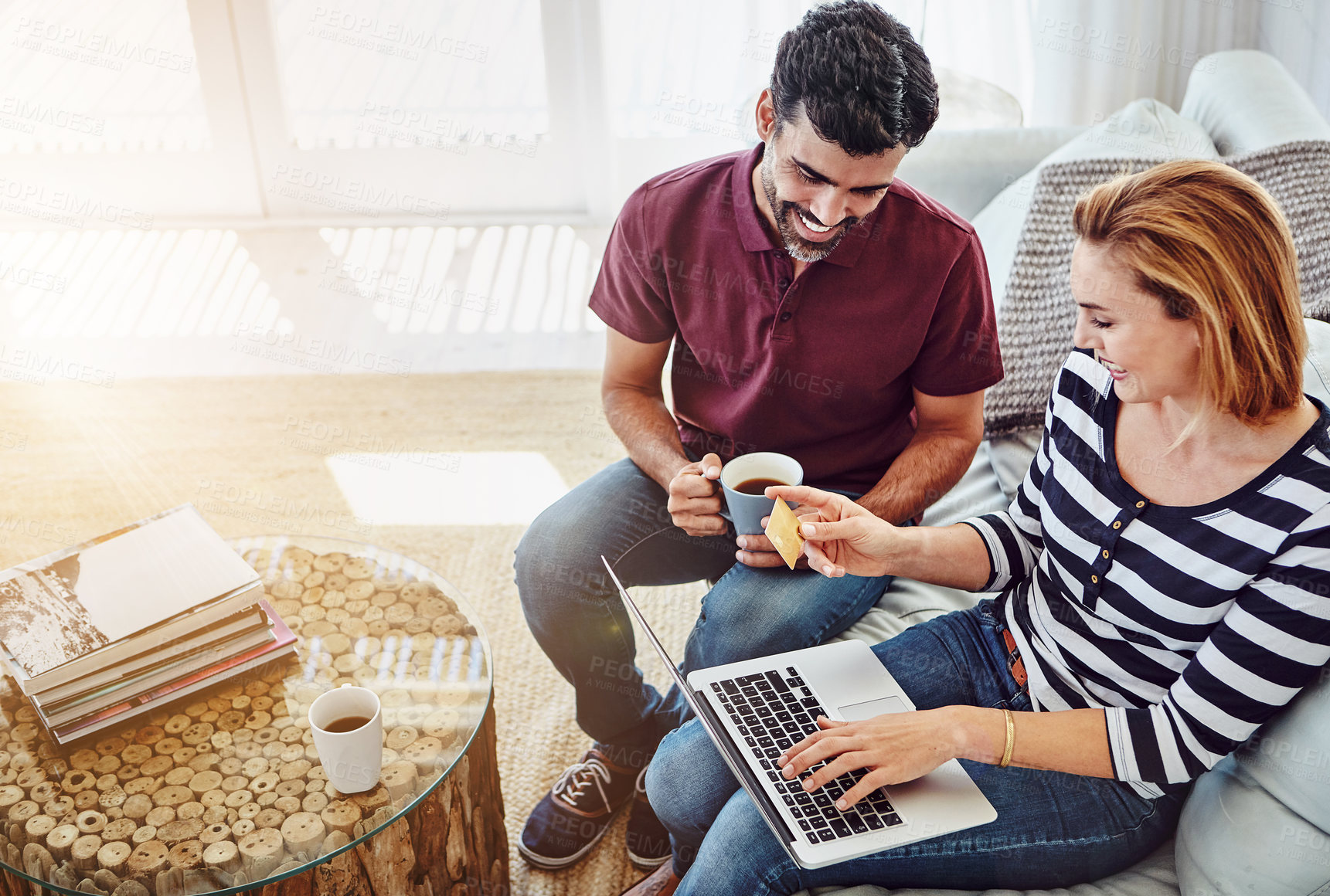 Buy stock photo High angle shot of an affectionate young couple shopping online at home