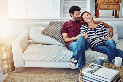 Buy stock photo High angle shot of an affectionate young couple relaxing on the sofa at home