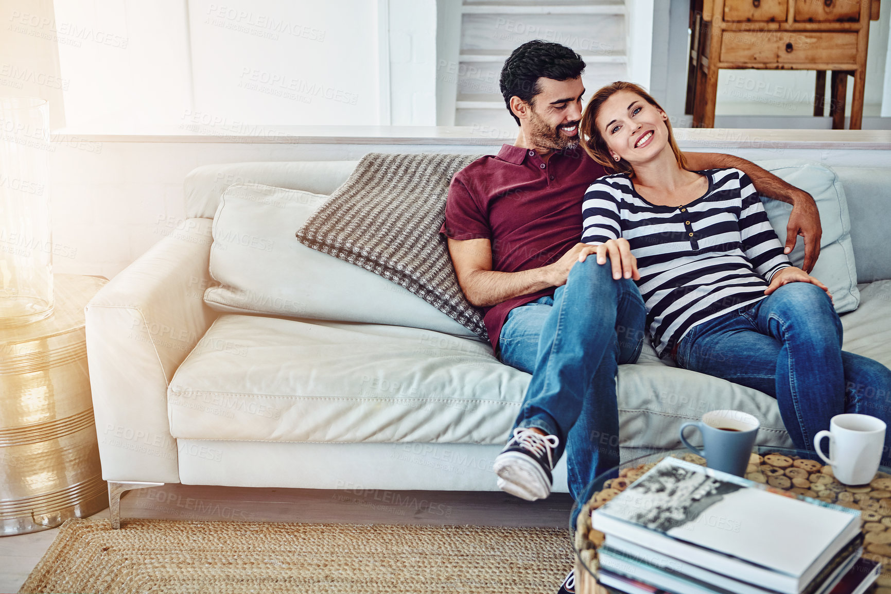 Buy stock photo High angle shot of an affectionate young couple relaxing on the sofa at home