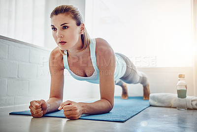 Buy stock photo Shot of a woman doing push-ups on her yoga mat