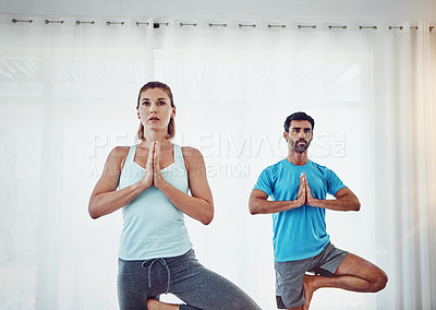 Buy stock photo Shot of a couple practising yoga at home