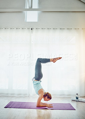 Buy stock photo Shot of an attractive woman practising her yoga routine at home