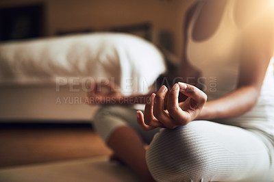 Buy stock photo Cropped shot of an unrecognizable young woman practicing yoga indoors