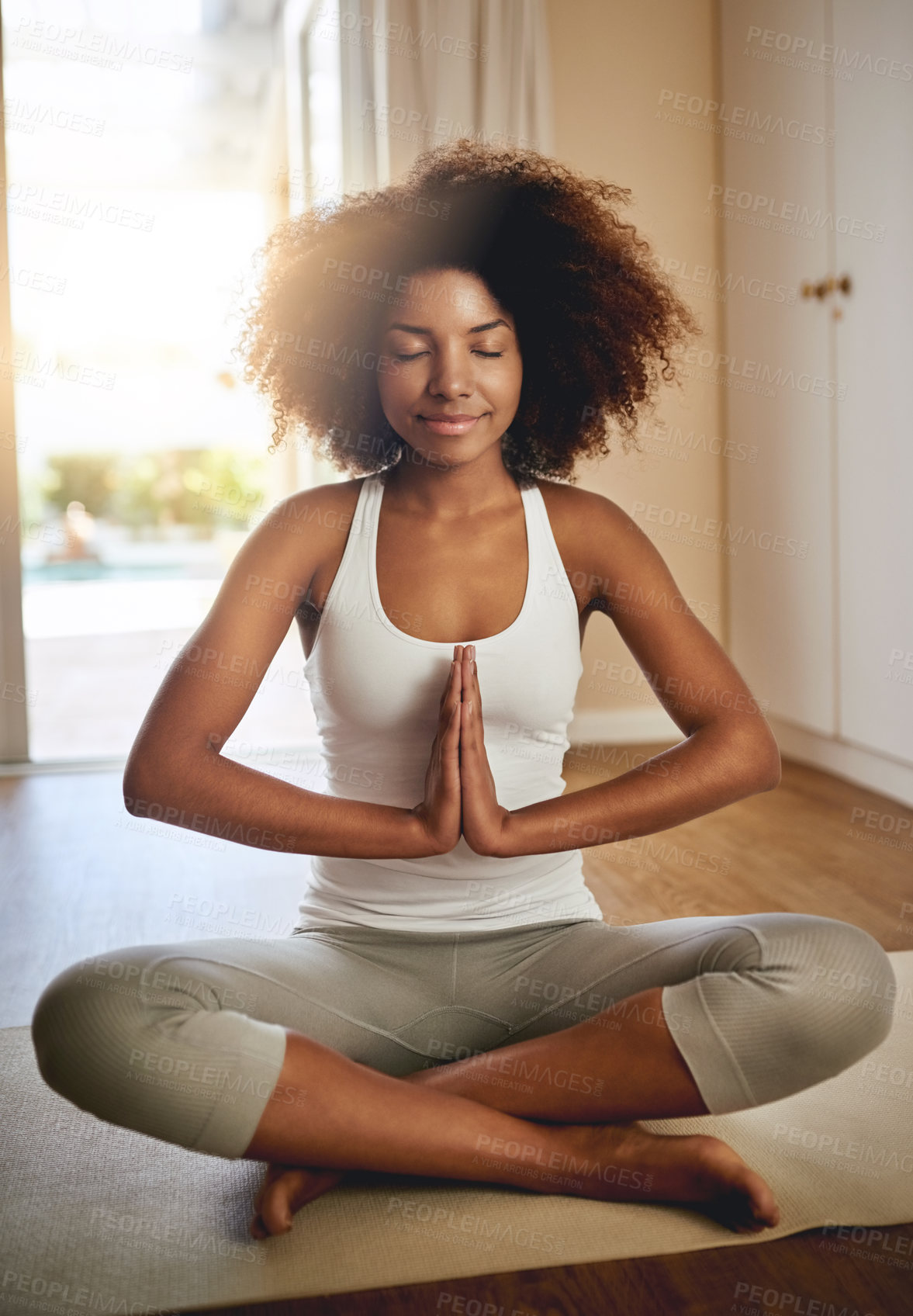 Buy stock photo Full length shot of a sporty young woman practicing yoga indoors