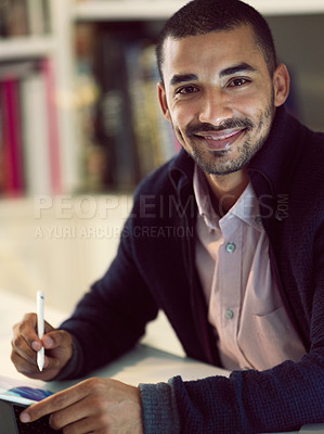 Buy stock photo Portrait of a smiling young man working on a digital tablet in his home office in the early evening