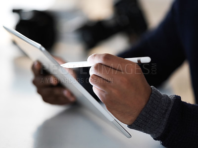 Buy stock photo Cropped closeup shot of an photographer sitting at a table using a digital tablet and pen