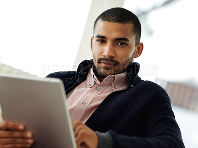 Buy stock photo Portrait of a focused young man working at home on a digital tablet
