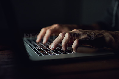 Buy stock photo High angle shot of an unidentifiable man using a laptop late at night