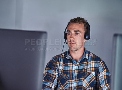 Buy stock photo Shot of a customer service agent wearing a headset while working at his computer
