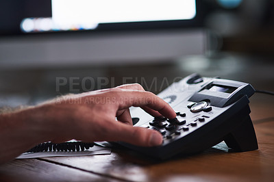 Buy stock photo Closeup of a corporate business man making a telephone call to a colleague, partner or client. A company employee, male executive or industry professional using a desk phone to contact a department 