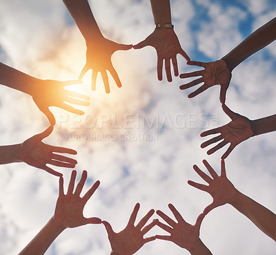Buy stock photo Low angle shot of a group of unidentifiable people making a circle with their hands against a cloudy sky