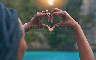 Buy stock photo Rearview shot of a happy young tourist making a heart with her hands against a beautiful landscape
