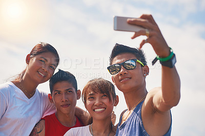 Buy stock photo Shot of a group of smiling friends taking a selfie together outside