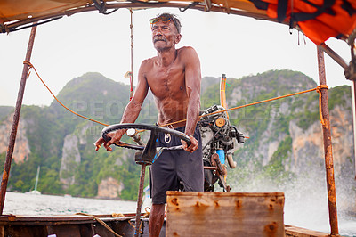 Buy stock photo Shot of a Thai man operating his tourist boat