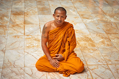 Buy stock photo Portrait of a buddhist monk sitting on a monastary floor