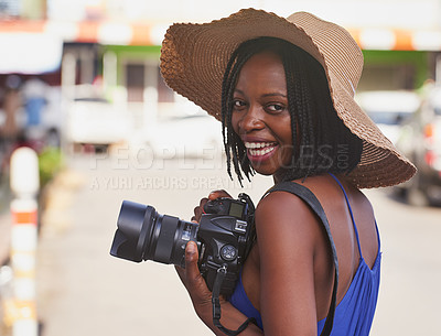 Buy stock photo Portrait of a happy young tourist taking pictures with her camera in a foreign city