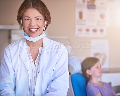 Buy stock photo Portrait of a female dentist standing in her office with her patient in the background
