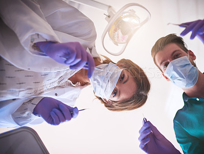 Buy stock photo Shot of two dentists getting ready to work on a patient