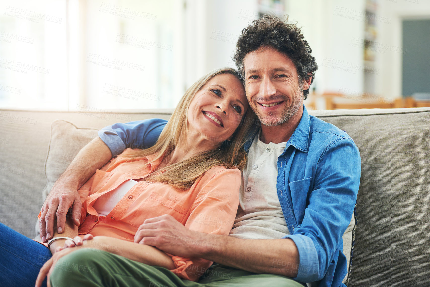 Buy stock photo Happy couple, couch and hug in home with love, marriage and romance for man and woman in living room. Sofa, smile or support or solidarity for relationship, relax or trust for commitment and embrace 