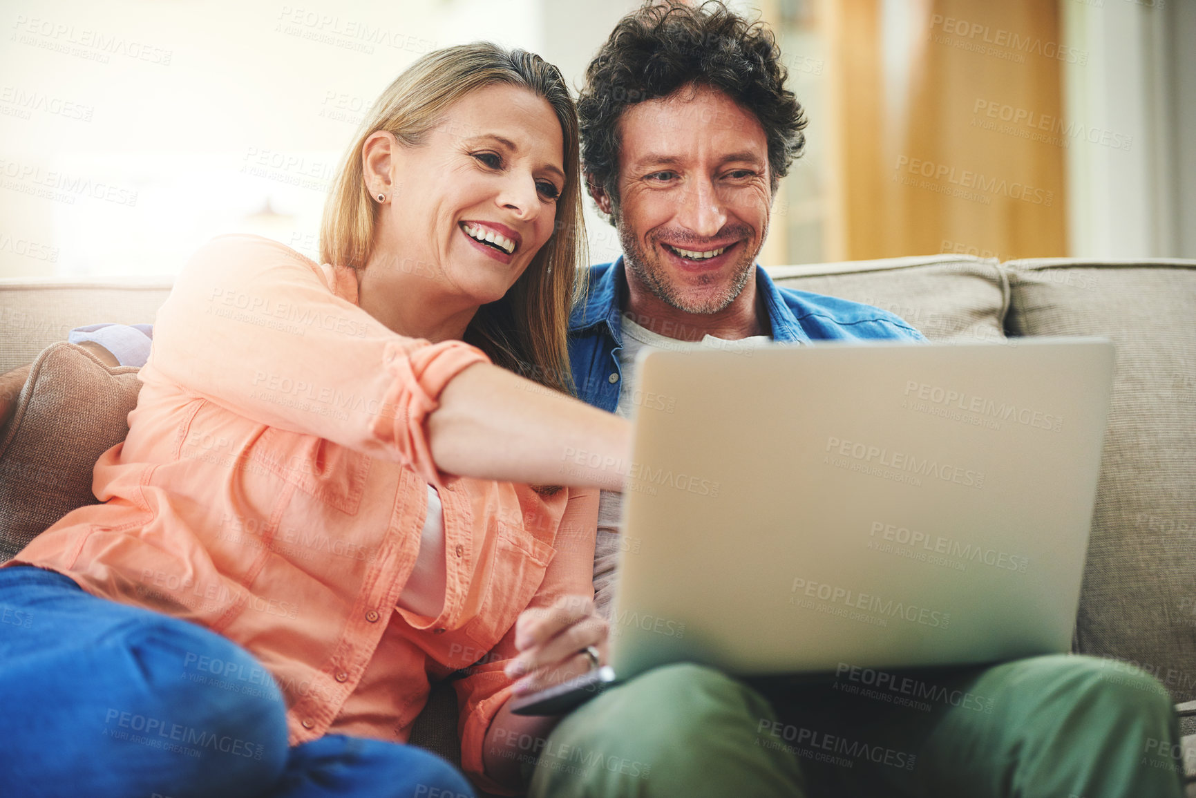 Buy stock photo Couple, sofa and laptop in home, relax and point for choice with movie, show or streaming subscription. Mature people, man and woman with computer on couch in living room with talking, film and smile