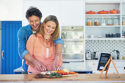 Buy stock photo Shot of a happy mature couple preparing a healthy meal together at home