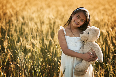 Buy stock photo Outdoor portrait, smile and girl with teddy bear for development, play and childhood in cornfield. Young child, happy and toy animal for bonding with healthy growth, space and calm weekend in nature