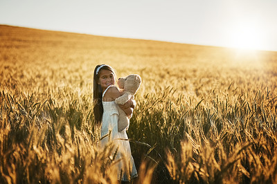 Buy stock photo Child, portrait and teddy bear in nature for love, care and hug in corn field or countryside. Young girl, embrace and toy for play in environment for holiday, growth and development or outdoor game