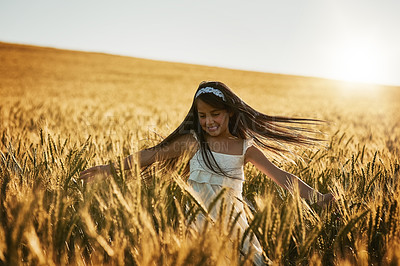 Buy stock photo Shot of a cute little girl twirling in a cornfield