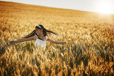 Buy stock photo Shot of a cute little girl twirling in a cornfield