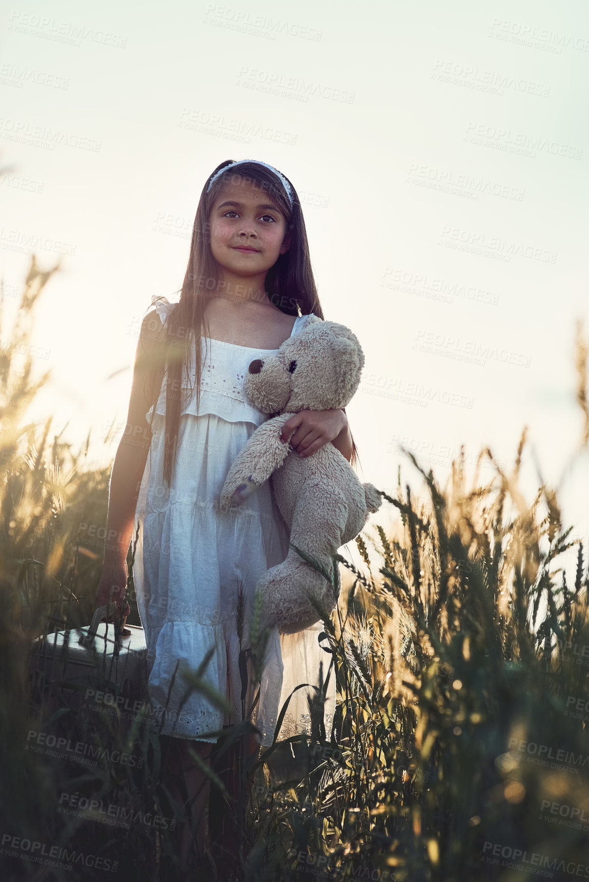 Buy stock photo Girl, thinking and teddy bear in nature for love, care and hug in corn field or countryside. Kid or child, embrace and toy for play in environment for holiday and idea or development for outdoor game