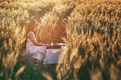 Buy stock photo Girl, field and typewriter for story and nature, peace and vintage writing equipment. Typing, author or young child person on farm in Texas for relax, calm or sunshine in summer with table or antique