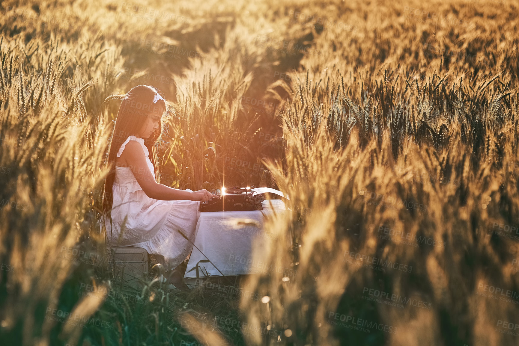 Buy stock photo Girl, field and typewriter for story and nature, peace and vintage writing equipment. Typing, author or young child person on farm in Texas for relax, calm or sunshine in summer with table or antique