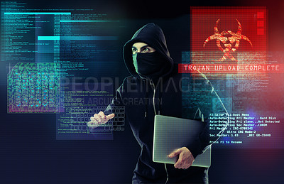Buy stock photo Shot of a computer hacker holding a laptop while standing against a dark background