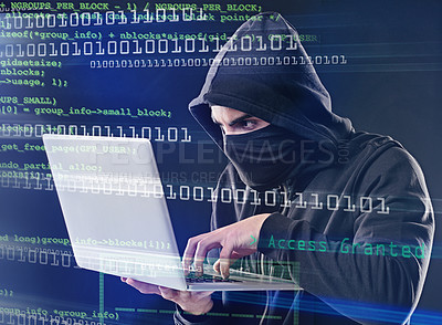 Buy stock photo Shot of a computer hacker using a laptop while standing against a dark background