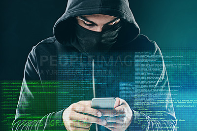Buy stock photo Shot of a computer hacker using a smartphone while standing against a dark background