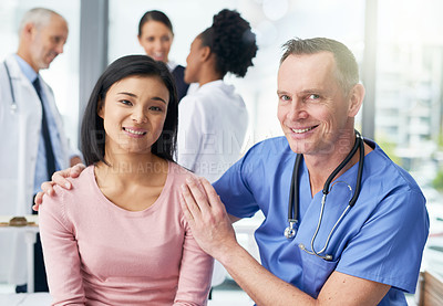 Buy stock photo Portrait of a happy doctor and his patient posing together in the clinic