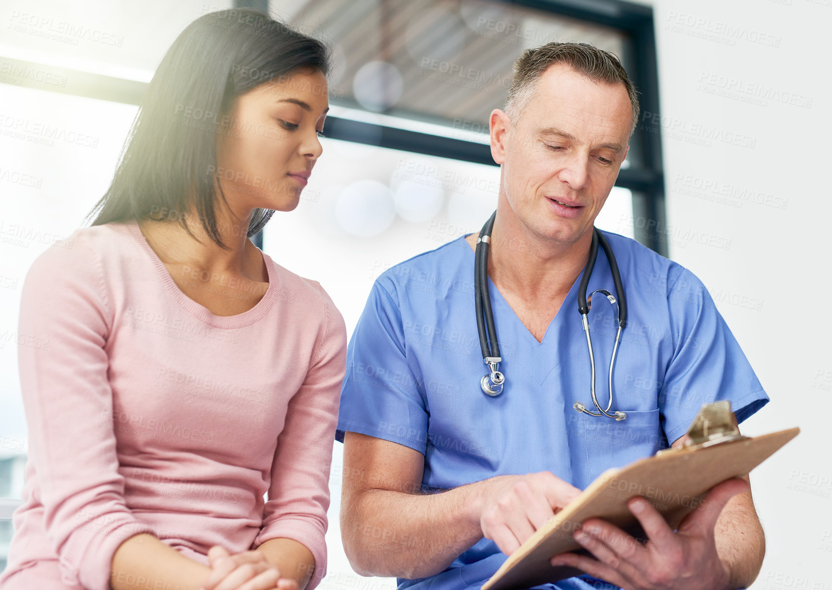 Buy stock photo Shot of a doctor consulting with his patient in the hospital