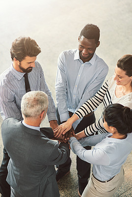 Buy stock photo High angle shot of a group of businesspeople standing in a huddle together in an office lobby