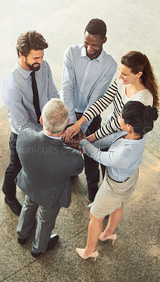 Buy stock photo High angle shot of a group of businesspeople standing in a huddle together in an office lobby