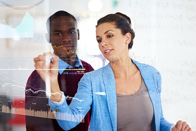 Buy stock photo Shot of two business colleagues using a digital interface while standing in a modern office