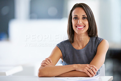 Buy stock photo Portrait of a smiling young businesswoman sitting at a desk in an office