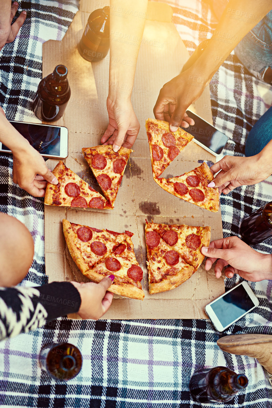 Buy stock photo Cropped shot of a group of friends eating pizza while having a picnic