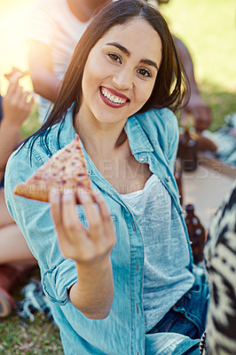 Buy stock photo Portrait of a young woman eating pizza while out on a picnic with friends