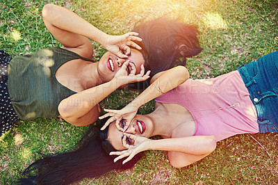 Buy stock photo Portrait of two young friends hanging out together at the park